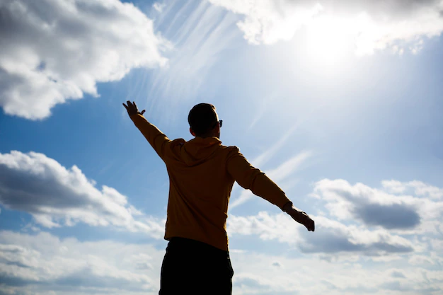 Guy tourist freelancer on a background of blue sky with white clouds, bright sunny day